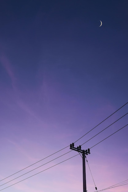 Ein lila Himmel mit ein paar Wolken und einem Strommast