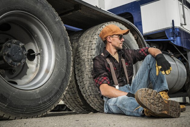 Foto ein lkw-fahrer ruht sich neben seinem lkw aus