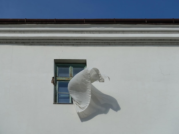 Ein loser Vorhang weht aus dem Fenster