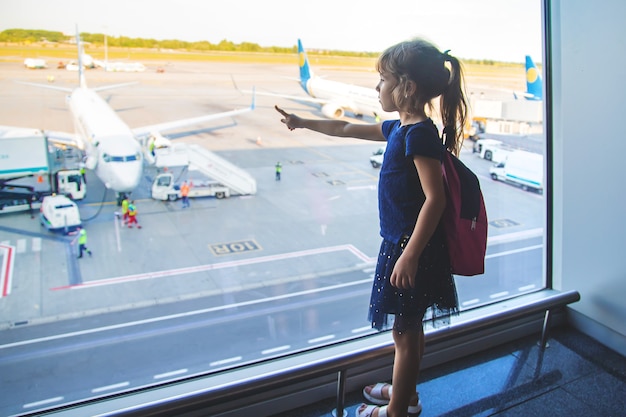 Ein Mädchen am Flughafen schaut sich die Flugzeuge an