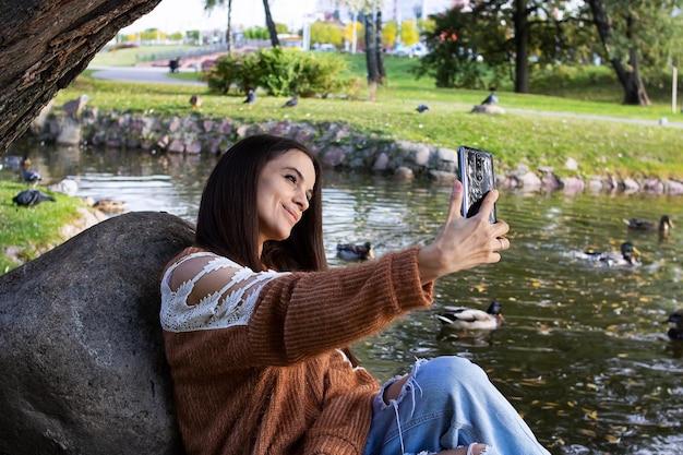 Ein Mädchen am Ufer des Sees macht ein Selfie
