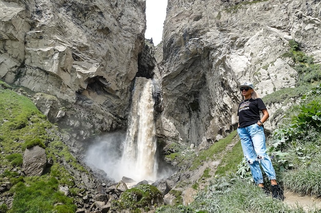 Ein Mädchen am Wasserfall Sultansu, umgeben von den Bergen des Kaukasus in der Nähe von Elbrus Jilysu Russland