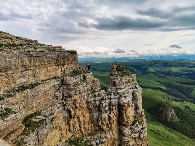 Ein Mädchen auf dem Hintergrund der Berge und des Bermamyt-Plateaus in Russland im Juni 2021