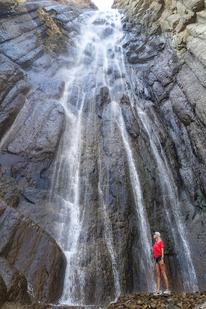 Ein Mädchen auf dem Hintergrund des AbaiSu-Wasserfalls Nordkaukasus KabardinoBalkarien Juni 2021