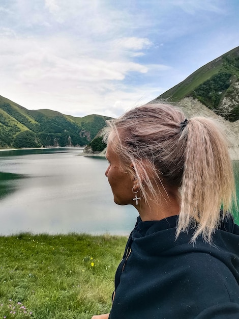 Ein Mädchen auf dem Hintergrund des Kezenoyam-Sees im Kaukasus in Tschetschenien, Russland, Juni 2021