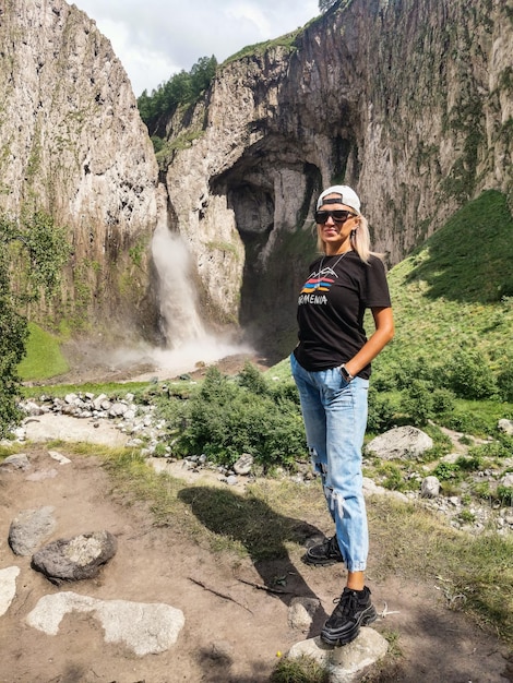 Ein Mädchen auf dem Hintergrund des Wasserfalls TuzlukShapa auf dem Territorium von KabardinoBalkarien Kaukasus Russland