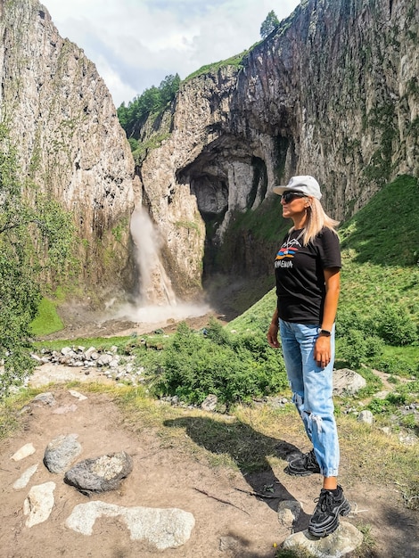 Ein Mädchen auf dem Hintergrund des Wasserfalls TuzlukShapa auf dem Territorium von KabardinoBalkarien Kaukasus Russland