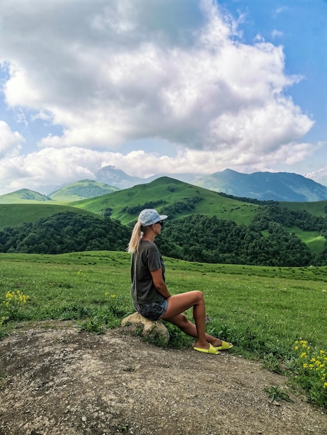 Ein Mädchen auf dem Hintergrund einer grünen Landschaft des Aktoprak-Passes im Kaukasus Russland Juni 2021