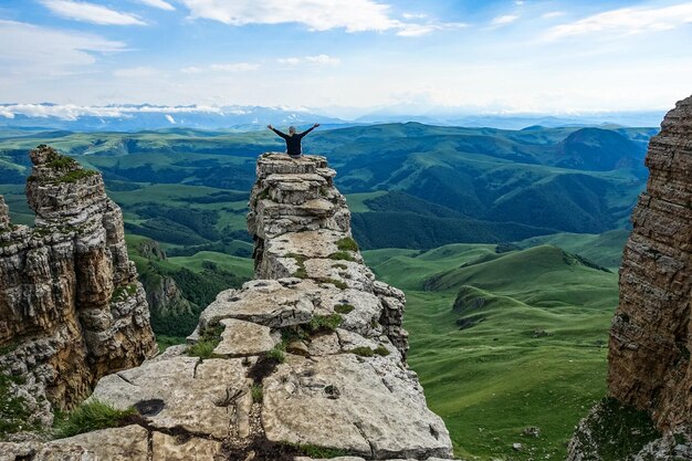 Ein Mädchen auf der Klippe des Plateaus vor dem Hintergrund des Mount Elbrus Bermamyt