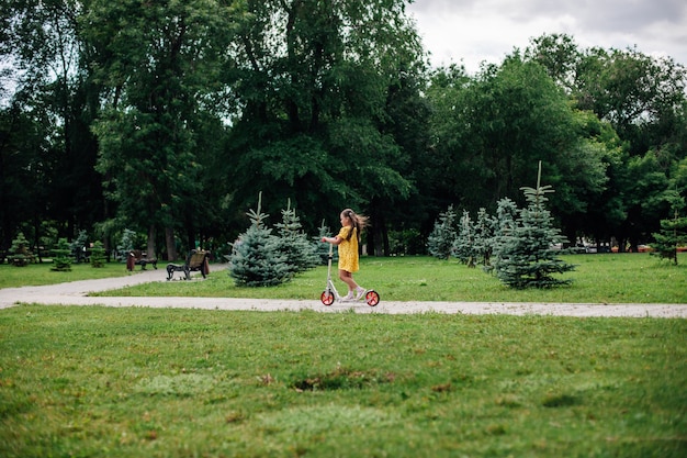 Foto ein mädchen auf einem roller ein nützlicher fitness-spaziergang durch den wald mit ihrer familie an einem sommerwochenende