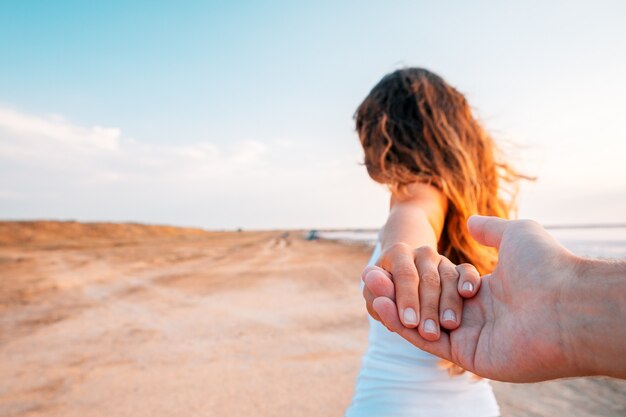 Ein Mädchen geht auf See und hält einen Kerl an der Hand