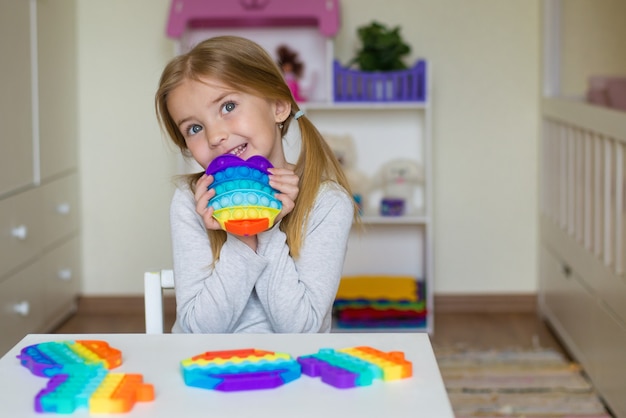 Ein Mädchen hält ein Pop-It-Spielzeug in den Händen