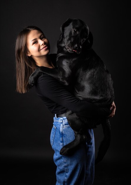 Ein Mädchen hält einen Labrador Retriever Hund im Arm