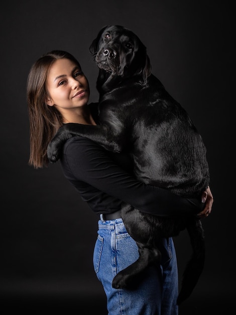 Ein Mädchen hält einen Labrador Retriever Hund im Arm