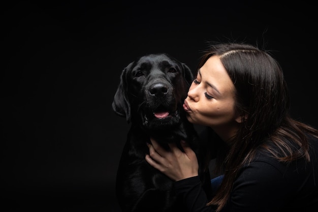 Ein Mädchen hält einen Labrador Retriever Hund im Arm