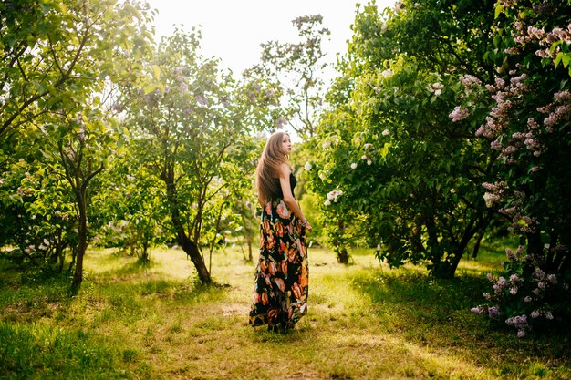 Ein Mädchen im blumigen Kleid in der Natur