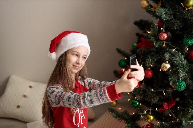 ein Mädchen im Neujahrspyjama das Mädchen schaut auf das Telefon