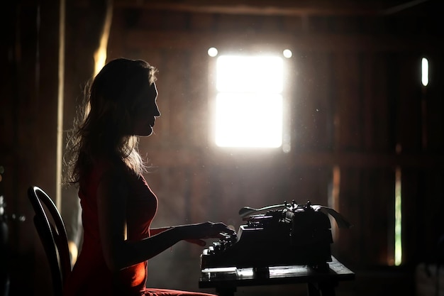 Ein Mädchen im Retrostil druckt auf einer alten Schreibmaschine