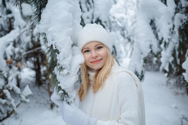 Ein Mädchen im Winterwald, blond, ein lustiger Spaziergang in der Natur