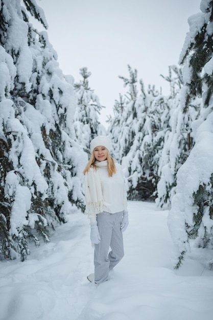 Ein Mädchen im Winterwald, blond, ein lustiger Spaziergang in der Natur