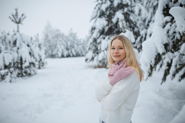 Ein Mädchen im Winterwald, blond, ein lustiger Spaziergang in der Natur