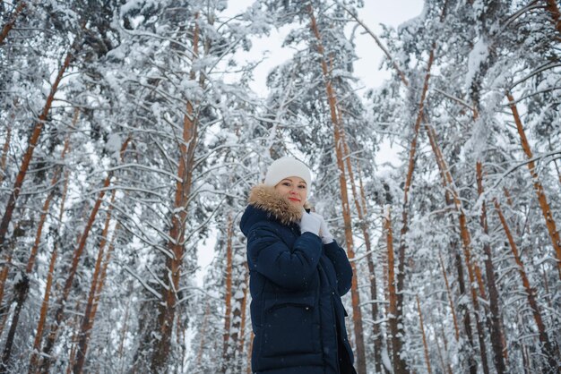 Ein Mädchen im Winterwald, blond, ein lustiger Spaziergang in der Natur