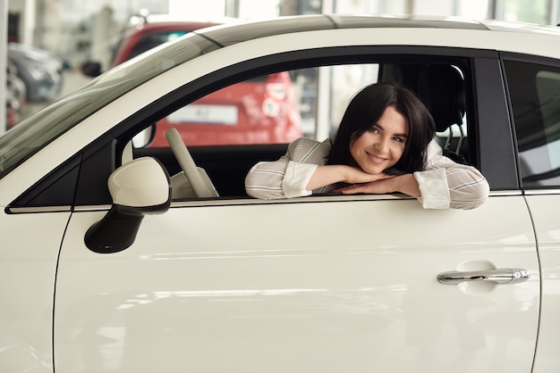 Ein Mädchen in einem Autohaus kauft ein kleines Stadtauto.