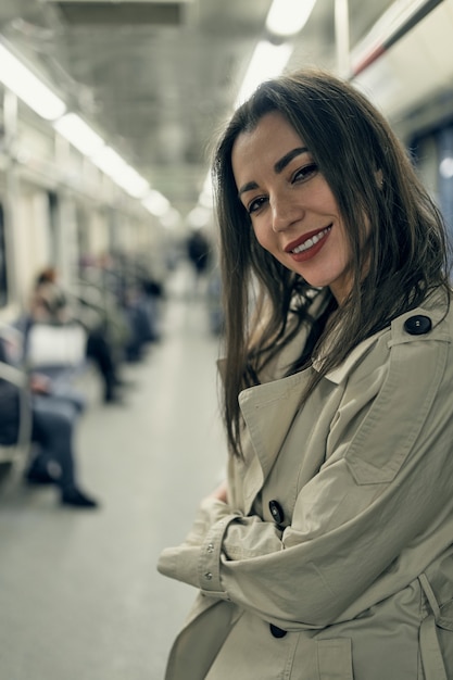 Ein Mädchen in einem beigen Trenchcoat fährt in einem U-Bahn-Wagen.