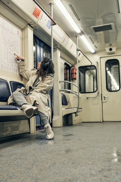 Foto ein mädchen in einem beigen trenchcoat fährt in einem u-bahn-wagen.