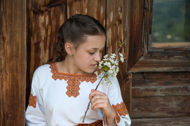 Ein Mädchen in einem bestickten Kleid mit einem Kirschblütenzweig. Ukrainische Nationaltracht.