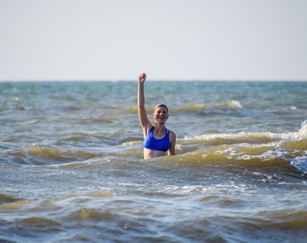 Ein Mädchen in einem blauen Badeanzug badet im Meer. Urlaub am Meer