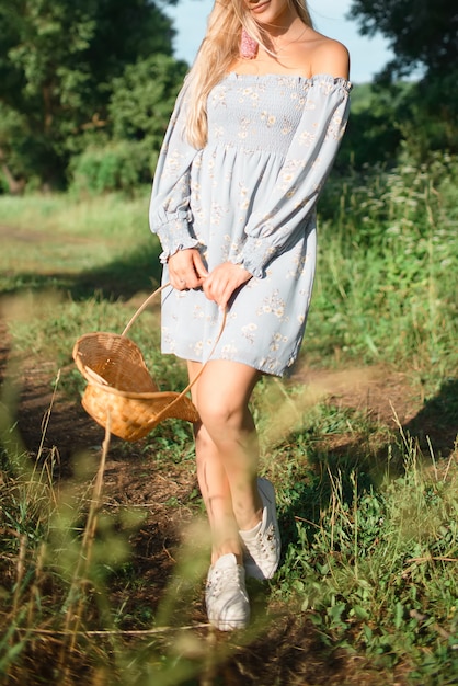 Ein Mädchen in einem blauen Kleid hält einen Blumenkorb