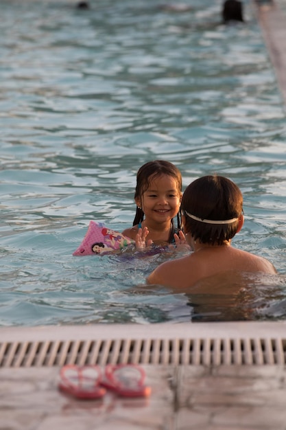 Ein Mädchen in einem Pool mit einem rosa Gegenstand auf dem Kopf