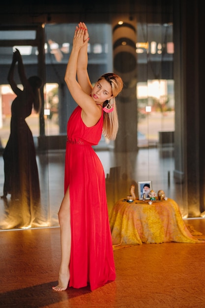 Ein Mädchen in einem roten Kleid bewegt sich in einem Tanz, der drinnen meditiert Dynamischer Tanz