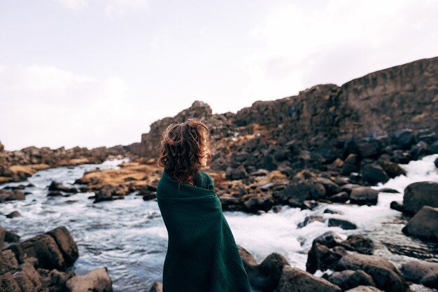 Ein Mädchen in einem roten Kleid in der Nähe von ehsaraurfoss fällt ehsarau River Nationalpark Tingwedlir sudurland