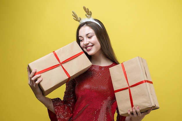 Ein Mädchen in einem roten Kleid mit Geschenk vor einem gelben Hintergrund