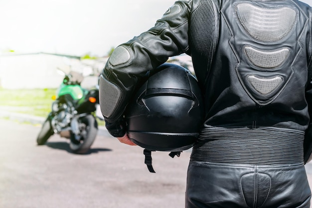 Ein Mädchen in einem Schutzanzug und einem schwarzen Helm sieht auf einem Sportmotorrad aus