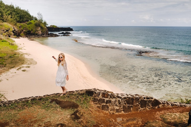 Ein Mädchen in einem weißen Kleid am Strand von GrisGris auf der Insel Mauritius