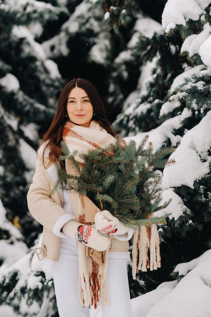 Ein Mädchen in einem Winterwald mit einem Strauß Tannenzweigen Verschneiter Winter