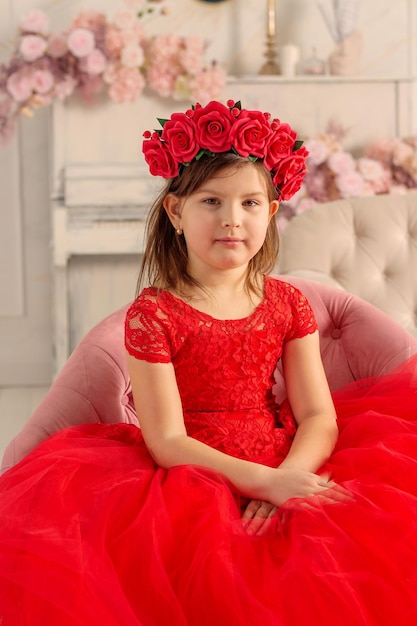 Ein Mädchen in einem wunderschönen Kleid und mit einem Blumenkranz auf dem Kopf Ein wunderschönes Mädchen FOTOSESSION Frühling