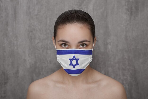 Ein Mädchen in einer Maske im Gesicht mit einer israelischen Flagge