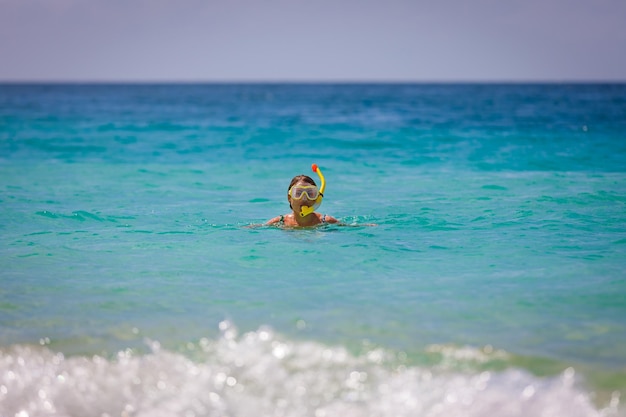 Ein Mädchen in einer Maske springt aus dem Meer