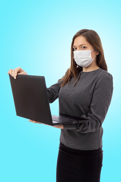 Ein Mädchen in einer medizinischen Maske hält einen Laptop in den Händen. Vertikales Banner