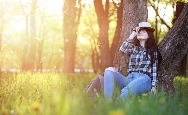 Ein Mädchen in Jeans und Hut verreist den Sommer auf dem Land