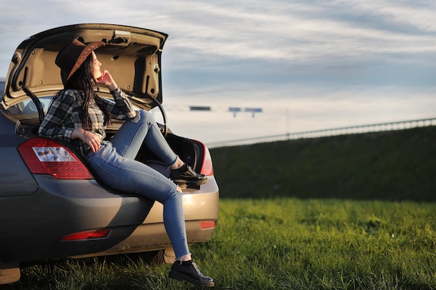 Ein Mädchen in Jeans und Hut verreist den Sommer auf dem Land