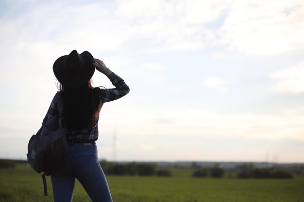 Ein Mädchen in Jeans und Hut verreist den Sommer auf dem Land