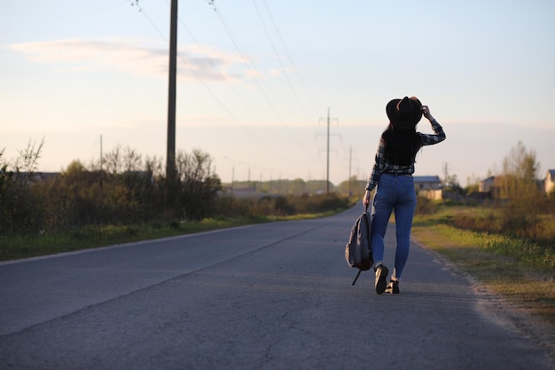 Ein Mädchen in Jeans und Hut verreist den Sommer auf dem Land