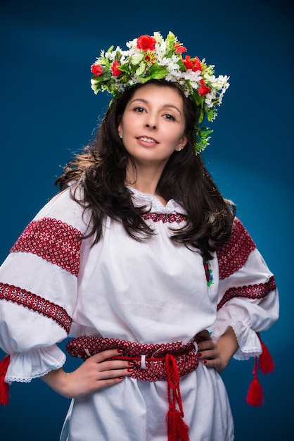 Ein Mädchen in nationaler Kleidung einer ukrainischen Frau auf blauem Hintergrund.