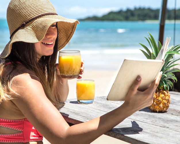 Ein Mädchen liest ein Buch am Meer