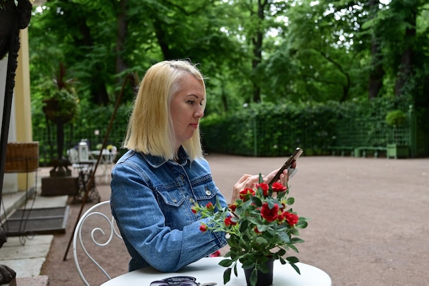 Ein Mädchen macht ein Selfie im Park Ein modisches Mädchen macht ein selfie mit einem Smartphone